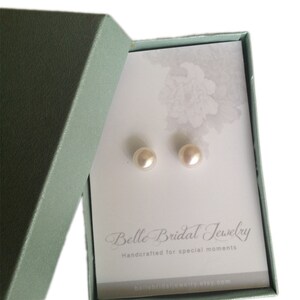 May include: A pair of pearl earrings in a light green box with a white card that reads "Belle Bridal Jewelry Handcrafted for special moments bellebridaljewelry.etsy.com"