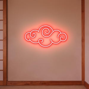 Puede incluir: Una lámpara de nube de neón rojo con un contorno blanco está montada en una pared beige. El diseño de la nube presenta formas arremolinadas. La luz es un elemento decorativo, adecuado para la decoración de interiores.