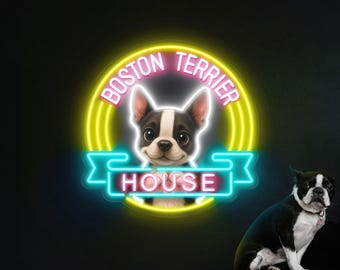 May include: A neon sign featuring a Boston Terrier dog with the text "BOSTON TERRIER HOUSE" in a vibrant yellow and pink design. A real Boston Terrier dog sits on a wooden stool to the right of the sign.