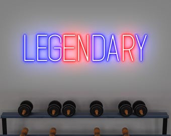 May include: A neon sign displaying the word "LEGENDARY" in blue and red. Below the sign, a rack holds several sets of dumbbells. The dumbbells are black with wooden handles. The background is a plain, light gray wall.