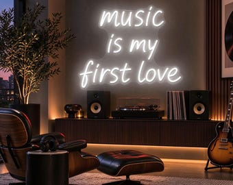 May include: A white neon sign mounted on a wall displaying the text music is my first love in a cursive script font. The sign is illuminated against a dark wall, creating a bright glow that highlights the lettering in a room setting.