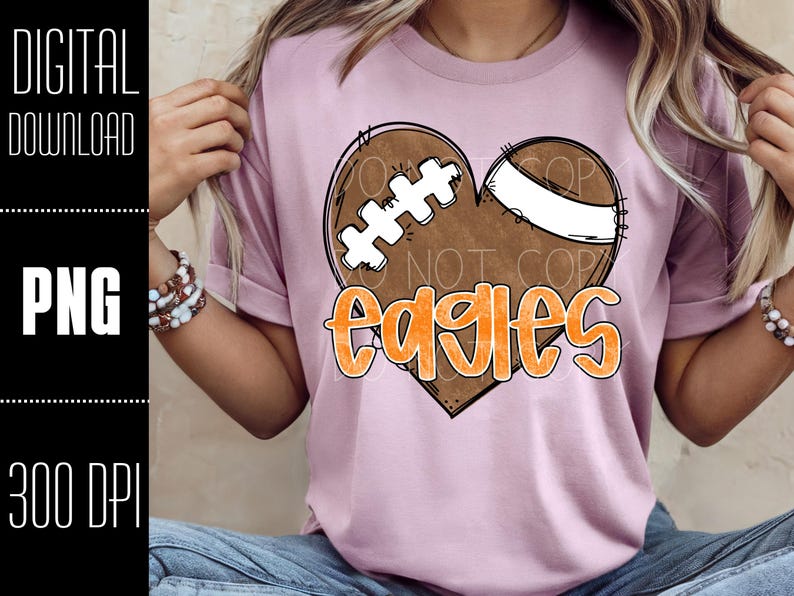 Puede incluir: Camiseta rosa claro con un dise&ntilde;o de coraz&oacute;n en forma de bal&oacute;n de f&uacute;tbol y la palabra "Eagles" en naranja. El coraz&oacute;n de f&uacute;tbol tiene detalles en blanco y marr&oacute;n. Las palabras "DIGITAL DOWNLOAD", "PNG" y "300 DPI" est&aacute;n en el lado izquierdo.