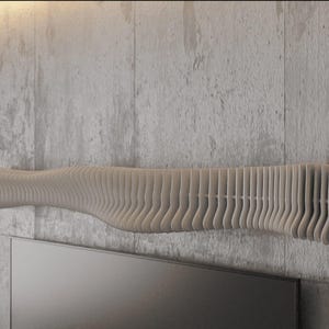 Pode incluir: Uma prateleira de parede moderna bege claro com um design ondulado único. A prateleira é construída a partir de painéis verticais em camadas, criando um efeito texturizado e tridimensional. É montada numa parede de betão cinzento, acima de uma televisão escura.