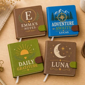 Puede incluir: Cuatro cuadernos cuadrados con cubiertas de colores y cierres magnéticos. El cuaderno marrón presenta la letra E y Emma's Notes. El azul muestra una brújula y Adventure Awaits Lucas. El verde muestra un sol y Daily Gratitude. El marrón oscuro muestra una luna y Luna.