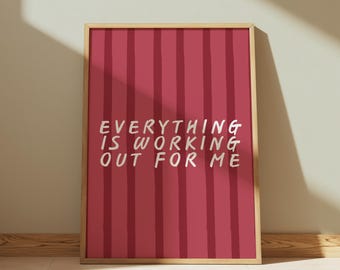 May include: A framed print with a red and white striped background and the text "EVERYTHING IS WORKING OUT FOR ME" in white.