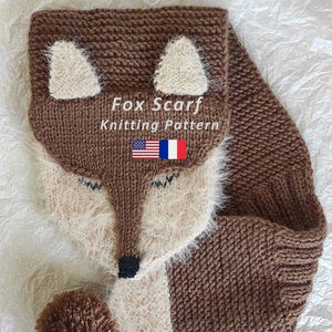 May include: A knitted fox scarf pattern in brown, cream, and black. The scarf features a fox face design with triangular ears, closed eyes, and a pom-pom tail. The text "Fox Scarf Knitting Pattern" is displayed.