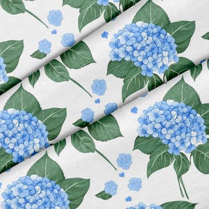 Puede incluir: Tela blanca con un patrón repetido de flores de hortensia azules y hojas verdes. Las flores están en plena floración, con pétalos detallados. Las hojas presentan intrincadas vetas. Adecuado para tela, papel pintado u otros usos decorativos.