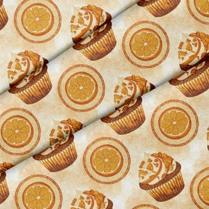 Könnte beinhalten: Ein Stoffmuster mit einem sich wiederholenden Design aus Cupcakes, die mit Orangenscheiben und Sahne belegt sind, durchsetzt mit kreisförmigen Orangenscheibenmotiven auf einem hellbeigen Hintergrund mit feiner Wirbellinienstruktur.