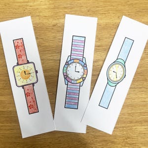 May include: Three colorful wristwatches with different colored bands and faces. The first watch has a red and orange floral band and a yellow face with black numbers. The second watch has a rainbow colored band and a white face with black numbers. The third watch has a light blue band and a yellow face with black numbers.