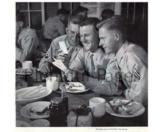 May include: Black and white photo of three soldiers sitting at a table eating. The soldiers are looking at a letter. The caption reads "They have given up so much, let us see to it that their thoughts are brightened with memories of home..." and "Visit him in SNAPSHOTS". The text "Kodak" is in a yellow box at the bottom of the image.