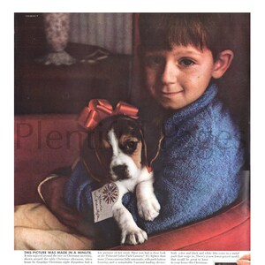 May include: A young boy in a blue sweater holds a beagle puppy wearing a red bow. The boy is sitting on a red and white couch. The image is a vintage advertisement for the Polaroid Color Pack Camera. The text in the image reads "This picture was made in a minute." and "Have you had a close look at the Polaroid Color Pack Camera? It's lighter than many cameras, fully automatic, with push-button viewing and a remarkable 7-second loading device."