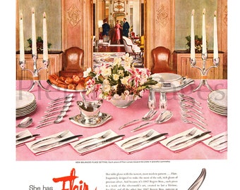 May include: A vintage 1847 Rogers Bros. advertisement featuring a dining table set with silver flatware, two silver candelabras with white candles, a floral centerpiece, and stacks of white plates on a pink tablecloth. Text includes She has Flair.