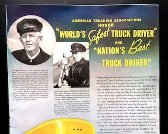 May include: A yellow International truck with a closed box trailer. The truck has a large International logo on the side. The text "WORLD'S Safest TRUCK DRIVER" and "NATION'S Best TRUCK DRIVER" is featured in the image.