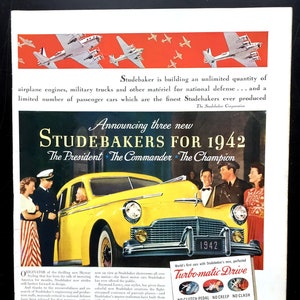 Könnte beinhalten: Eine Vintage-Werbung für Studebaker-Autos aus dem Jahr 1942. Die Anzeige zeigt ein gelbes Studebaker-Auto mit dem Text "Announcing three new Studebakers for 1942" und "The President, The Commander, The Champion". Die Anzeige hebt auch die neue Turbo-matic Drive hervor, die als "World's first cars with Studebaker's new, perfected Turbo-matic Drive" beschrieben wird.