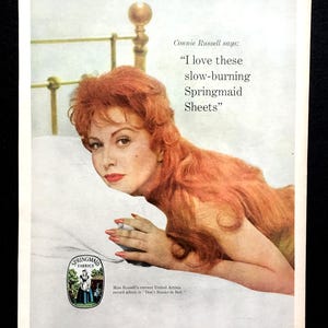 May include: Vintage advertisement featuring Connie Russell promoting Springmaid Sheets. The image shows Russell on a bed, with text that reads, "I love these slow-burning Springmaid Sheets." The Springmaid Fabrics logo is also visible.