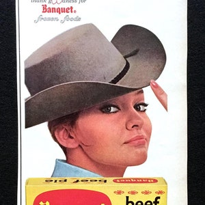 May include: A vintage advertisement for Banquet brand frozen beef pie. The ad features a woman wearing a cowboy hat and a close-up of the pie with a flaky crust and a filling of beef, peas, and carrots. The text reads "Keep it under your hat. This beef pie isn't really homemade. Banquet did the fixin' - from the potatoes an' vegetables an' tender crust to the big flavorful chunks of beef. Expensive? Heck no! Just tastes expensive! Thank goodness for Banquet. Frozen foods."