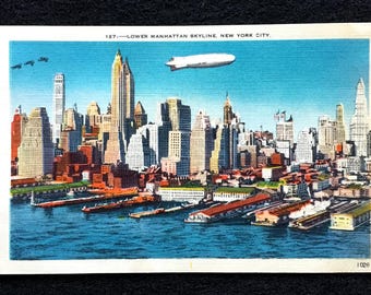 May include: Vintage postcard featuring the Lower Manhattan skyline in New York City. The image shows a vibrant cityscape with numerous skyscrapers, a blimp, and boats on the water. The postcard has the text "127 - LOWER MANHATTAN SKYLINE, NEW YORK CITY."