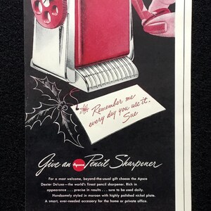 May include: A vintage advertisement for a maroon Dexter pencil sharpener with a nickel-plated base. The text reads: For Lasting Appreciation, Remember me every day you use it. Sue, Give an Apsco Pencil Sharpener, and Automatic Pencil Sharpener Co.