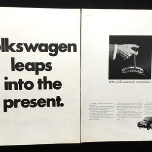 May include: A vintage black and white print advertisement featuring the bold text Volkswagen leaps into the present. The layout includes a graphic of an automatic gear shifter and two small cars, with descriptive paragraphs detailing the vehicle features.