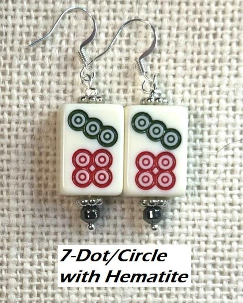May include: Pair of white rectangular earrings featuring a 7-dot/circle design in red and green, with hematite beads. The earrings have silver-coloured hooks. Text reads "7-Dot/Circle with Hematite".