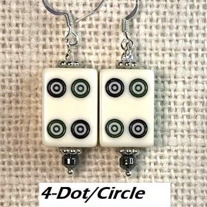 May include: Earrings with ivory-coloured rectangular tiles, each displaying four black and green circles. The earrings have silver hooks and hematite beads. The text "4-Dot/Circle with Hematite" is at the bottom.