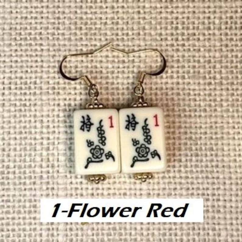 Puede incluir: Pendientes con colgantes rectangulares blancos con caracteres chinos negros, un n&uacute;mero 1 rojo y un dise&ntilde;o floral. Los pendientes tienen ganchos dorados. El texto "1-Flower Red" est&aacute; en la parte inferior.