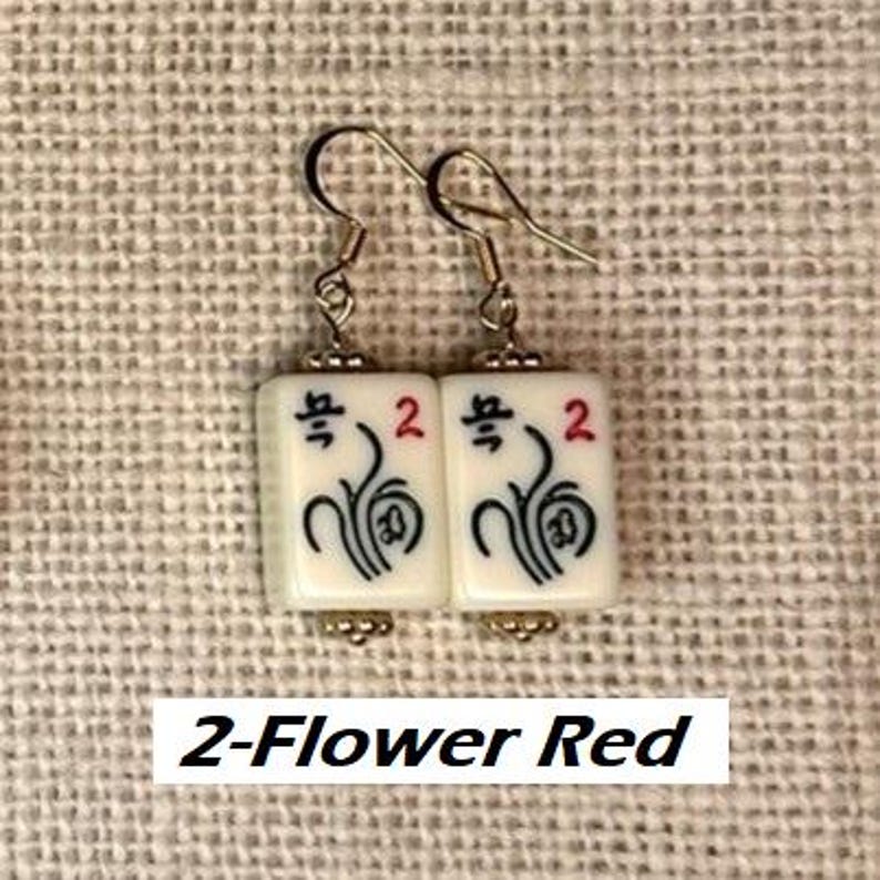 Puede incluir: Pendientes con baldosas rectangulares blancas con s&iacute;mbolos negros y rojos, incluido el n&uacute;mero 2 y un dise&ntilde;o floral. Los pendientes tienen ganchos plateados. El texto "2-Flower Red" est&aacute; en la parte inferior.