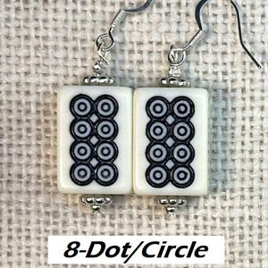 May include: Earrings featuring a white rectangular tile design with a black 8-dot circle pattern. The earrings have silver-tone hooks and decorative elements. The text "8-Dot/Circle" is visible at the bottom of the image.