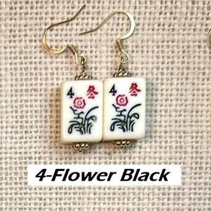 Puede incluir: Pendientes con baldosas rectangulares blancas, cada una con un dise&ntilde;o floral y el n&uacute;mero 4. Los pendientes tienen ganchos dorados. El texto "4-Flower Black" es visible en la parte inferior.
