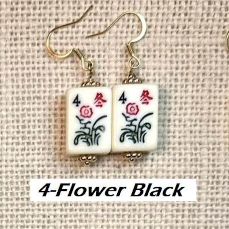 Puede incluir: Pendientes con baldosas rectangulares blancas, cada una con un dise&ntilde;o floral y el n&uacute;mero 4. Los pendientes tienen ganchos dorados. El texto "4-Flower Black" es visible en la parte inferior.
