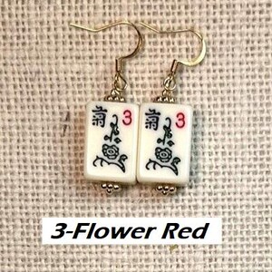 Puede incluir: Pendientes dorados con baldosas blancas rectangulares. Cada baldosa presenta un dise&ntilde;o negro y rojo, que incluye un motivo floral, el n&uacute;mero 3 y caracteres chinos. El texto "3-Flower Red" est&aacute; en la parte inferior.
