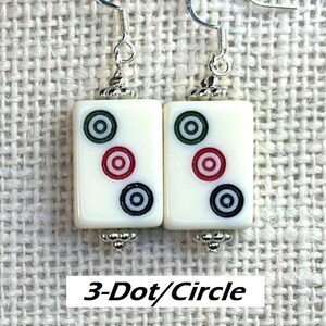 May include: Earrings with rectangular white tiles, each displaying a 3-dot/circle pattern in red, green, and black. They have silver-tone hooks and decorative metal details. The text "3-Dot/Circle" is present.