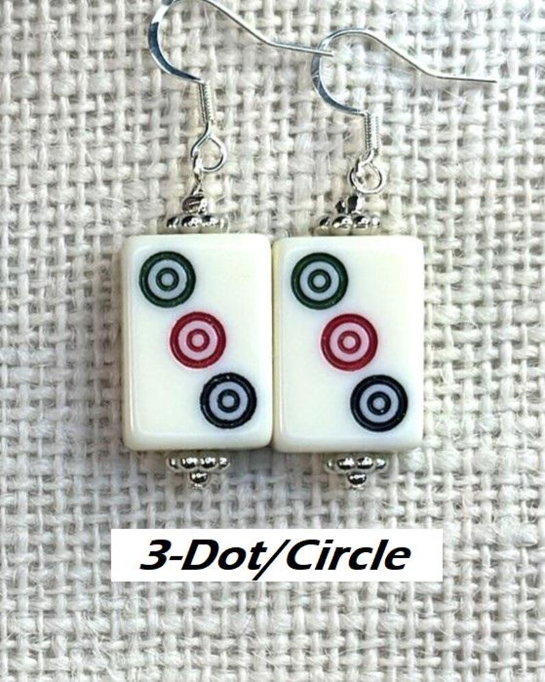 May include: Earrings with rectangular white tiles, each displaying a 3-dot/circle pattern in red, green, and black. They have silver-tone hooks and decorative metal details. The text "3-Dot/Circle" is present.