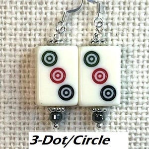 May include: Cream-coloured rectangular earrings with three circles in green, red, and black. The earrings have silver hooks and hematite beads. Text on the image reads "3-Dot/Circle with Hematite."