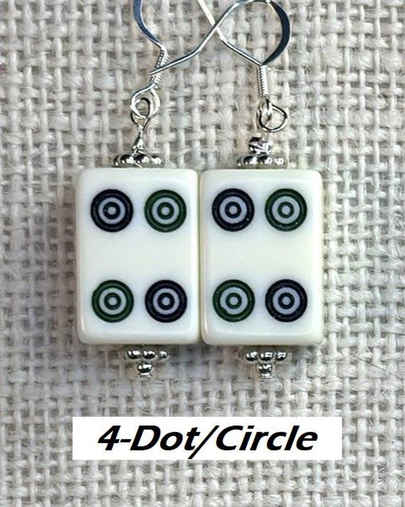 May include: White rectangular earrings featuring four black and green circle designs. The earrings have silver-coloured hooks and decorative beads. The text "4-Dot/Circle" is at the bottom of the image.