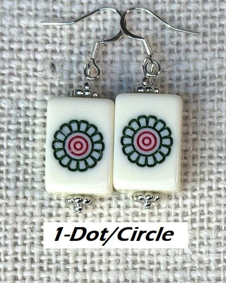 May include: Earrings with rectangular, off-white tiles, each displaying a floral pattern in green, red, and light blue. The earrings have silver-tone hooks and decorative metal elements. The text "1-Dot/Circle" is at the bottom.