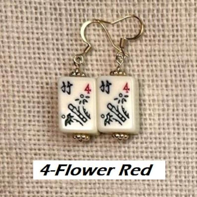 Puede incluir: Pendientes dorados con colgantes rectangulares blancos con s&iacute;mbolos negros y rojos, incluido el n&uacute;mero 4 y bamb&uacute;. Los pendientes est&aacute;n etiquetados como "4-Flower Red".