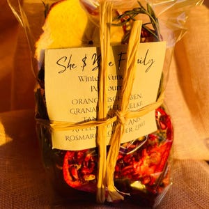 Könnte beinhalten: Ein transparenter Plastikbeutel gefüllt mit getrockneten Früchten und Kräutern, zusammengebunden mit einer Schnur. Der Beutel ist mit "She $e Fuly Winter Vund Po surr ORANG ISCH BEN. GRANAT FELELKE TANNO AFTELS ROSMARI LIBANIS OER ZIMT" beschriftet.