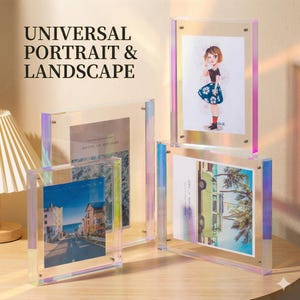 May include: Clear acrylic photo frames with iridescent edges, displaying various images. The frames are arranged on a wooden surface, with the text "UNIVERSAL PORTRAIT & LANDSCAPE" visible in the upper left corner. The frames hold photos of a street scene, a drawing of a person, and a vintage car.