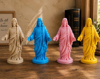 Könnte beinhalten: Vier stehende Jesus-Christus-Figuren, jede auf einem runden Sockel, in einer Reihe angeordnet. Die Figuren sind beige, leuchtend blau, hellrosa und gelb und zeigen langes Haar, einen Bart und Gewänder mit drapierten Falten.