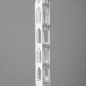 Pode incluir: Uma maquete arquitetónica alta e branca de uma torre gótica de três níveis, com arcos apontados, traceria intrincada nas janelas e uma base hexagonal. A estrutura está orientada verticalmente com uma agulha pontiaguda no topo.
