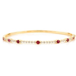 Pode incluir: Um bracelete de ouro com uma fila de pequenos rubis vermelhos redondos e diamantes brancos.