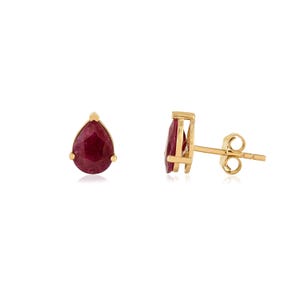 May include: A pair of gold stud earrings featuring pear-shaped, deep red gemstones. The earrings have a simple, elegant design with a post and butterfly backing. The gemstones are set in a gold bezel setting.