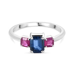 Puede incluir: Un anillo de plata con tres piedras preciosas. La piedra central es un gran zafiro azul rectangular. Las dos piedras más pequeñas a cada lado son rubíes rosas cuadrados.