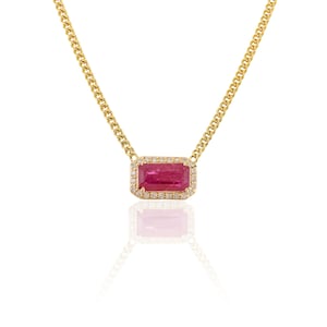 May include: A gold necklace featuring a rectangular, ruby-coloured gemstone pendant. The pendant is surrounded by a halo of small, clear gemstones. The chain has a curb link design.