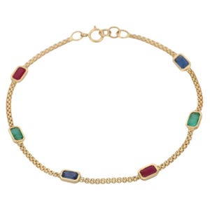 May include: A gold bracelet featuring a delicate chain design. The bracelet is adorned with rectangular gemstones in red, blue, and green. The gemstones are evenly spaced along the chain, creating a colorful and elegant accessory.