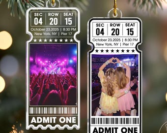 May include: Two clear acrylic ticket-shaped ornaments. One shows a concert crowd, the other a photo of two people. Both have the text "SEC 04 ROW 20 SEAT 15" and "October 23, 2025 | 8:30 PM New York, NY | Pier 17". The bottom reads "ADMIT ONE".