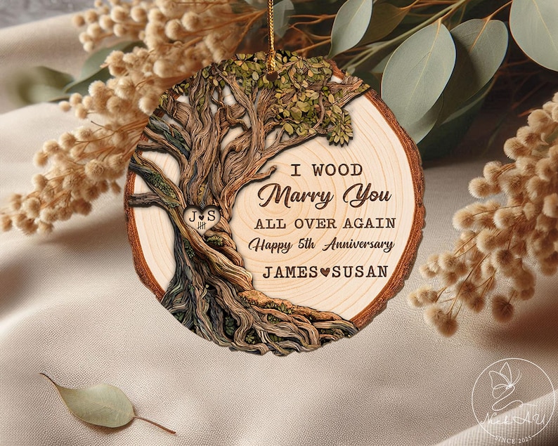 Op de afbeelding: Houten boomstam ornament met de tekst "I Wood Marry You All Over Again Happy 5th Anniversary JAMES SUSAN". Het ornament heeft een gedetailleerd boomontwerp met een hart en initialen.
