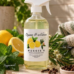 May include: A clear glass spray bottle containing a light yellow liquid with a white label reading Organic & Natural Maggie's Mould Remover Spicy Citrus Blend Hand Made 500ml, featuring illustrations of lemons, tea tree, and peppermint.