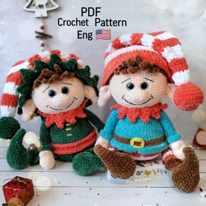 Puede incluir: Dos muñecos de duende de ganchillo hechos a mano. Un muñeco lleva un traje verde con cuello rojo y un gorro a rayas verdes y blancas. El otro muñeco lleva un traje azul con cuello rojo y un gorro a rayas rojas y blancas. El texto "PDF Crochet Pattern Eng" está en la imagen.